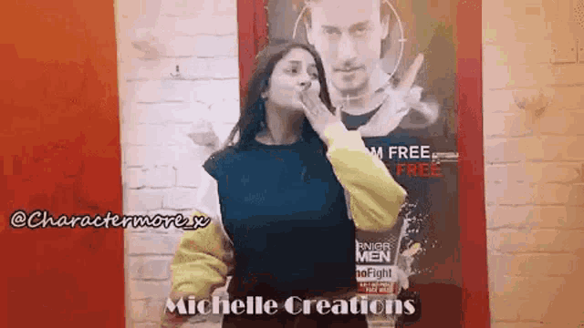 a woman is standing in front of a poster of a man and covering her mouth .