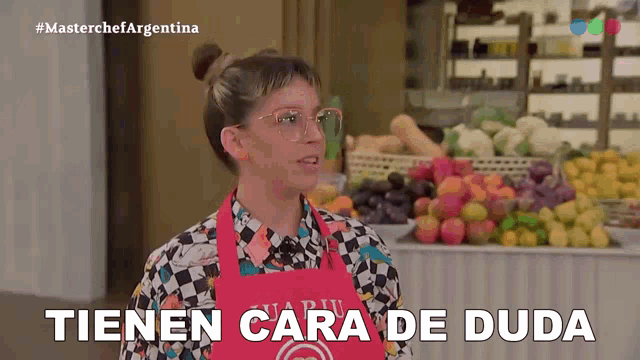 a woman wearing a red apron says tienen cara de duda