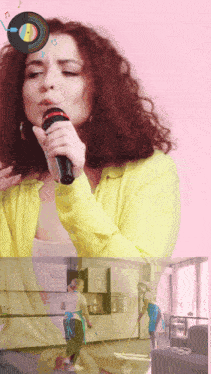 a woman singing into a microphone with a record on her head
