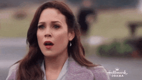 a close up of a woman 's face with a hallmark drama logo in the background