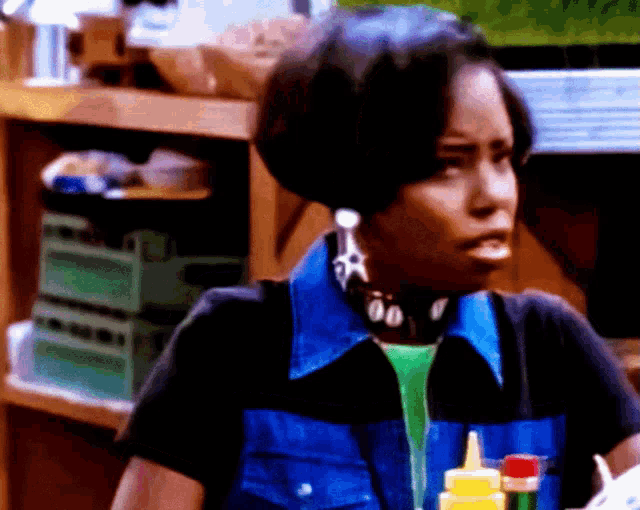 a woman wearing a blue vest with a star earring