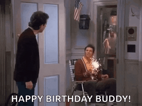 a man is standing next to a man sitting in a chair holding a sparkler and saying happy birthday buddy .