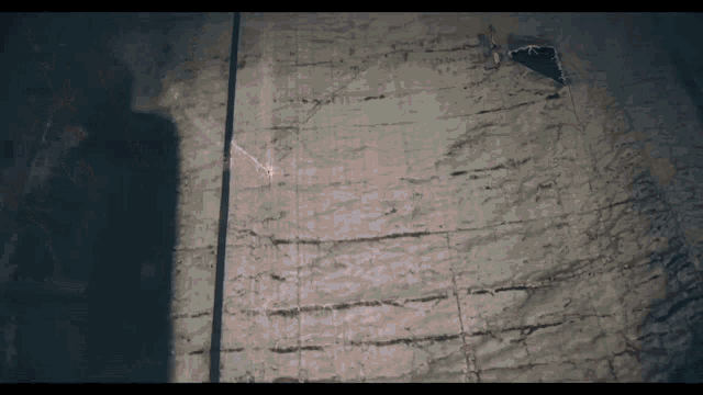a shadow of a person is cast on a concrete wall