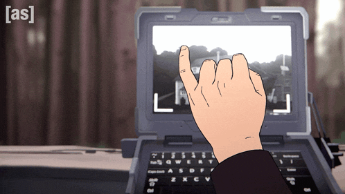 a person 's hand is pointing at a laptop screen with the letter l on it