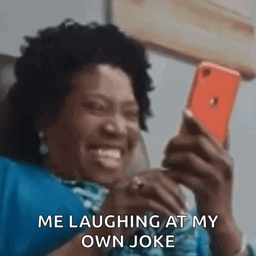 a woman is laughing while looking at her phone
