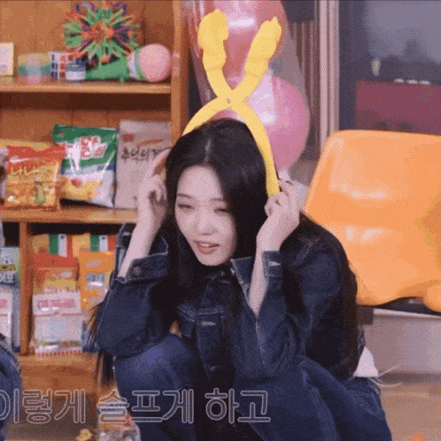 a girl wearing a yellow headband with a pair of scissors on it