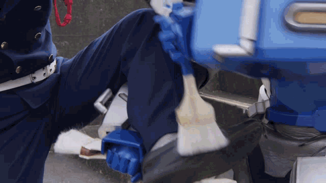 a person wearing blue pants and white gloves is holding a shovel