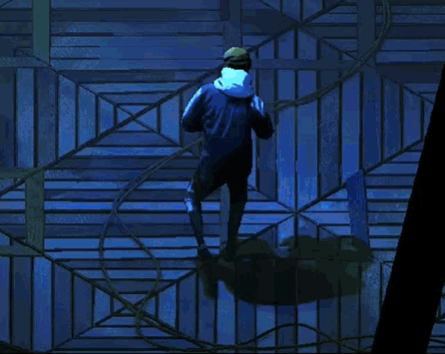 a man in a blue jacket is standing in front of a blue fence