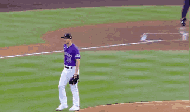 a baseball player wearing a purple jersey that says colorado on it