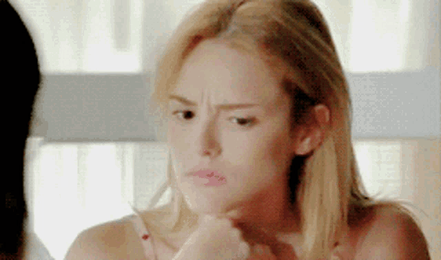 a close up of a woman 's face making a funny face