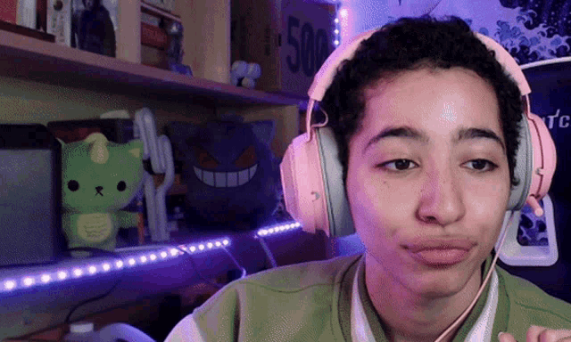 a person wearing pink headphones with the number 500 on the shelf behind them
