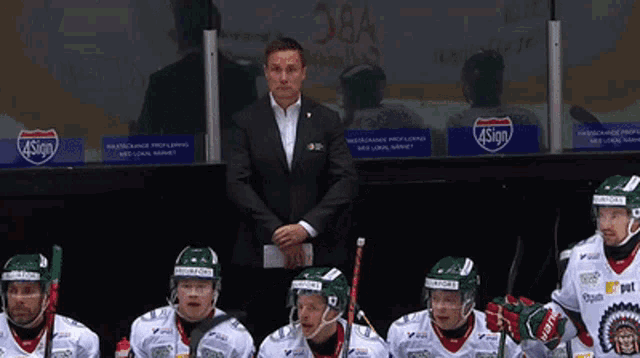 a group of hockey players are sitting in a locker room with a sign that says 4sign on it