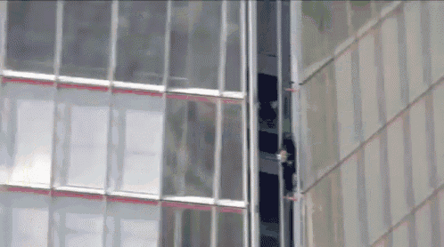 a very tall building with a lot of windows and a person looking out of one of the windows