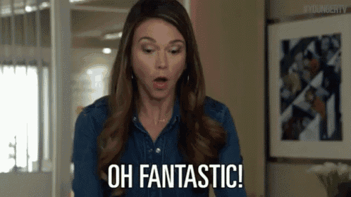 a woman in a denim shirt is standing in a room and says oh fantastic .