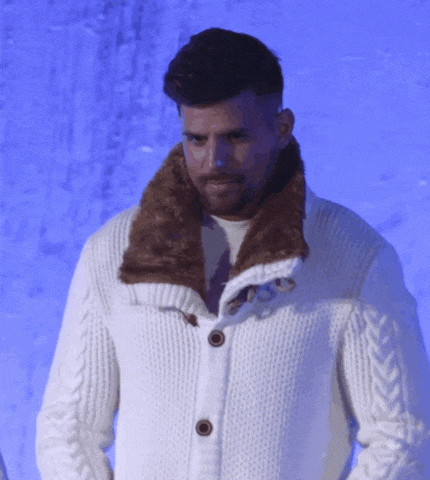 a man wearing a white sweater with a fur collar and buttons