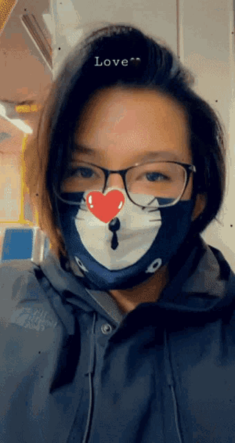 a woman wearing glasses and a mask with the word love written on her forehead