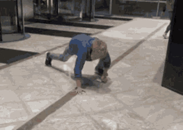 a little boy is crawling on the floor in a hallway