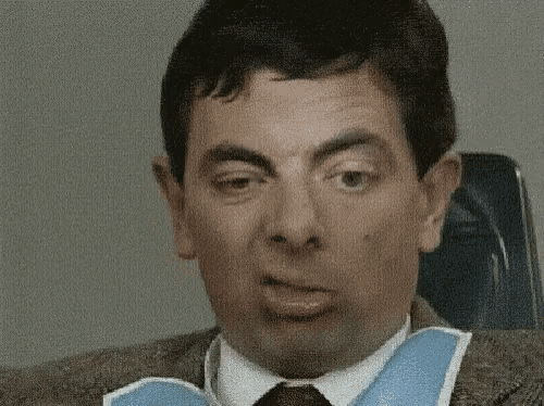 a man in a suit and tie is making a funny face while wearing a bib around his neck .