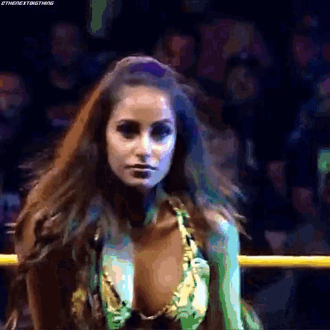 a woman in a bikini is standing in a ring with a crowd watching .