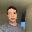 a young man is taking a selfie in front of a mirror while wearing ear buds .