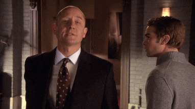 a man in a suit and tie talks to another man