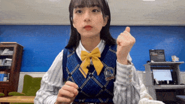 a girl wearing a blue vest with a yellow bow and a badge that says ' lions ' on it