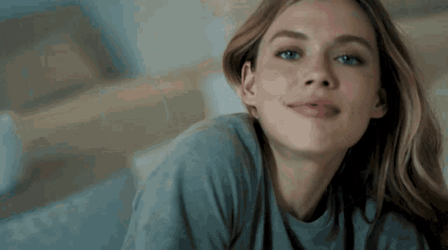 a close up of a woman 's face with a blue shirt on