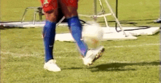 a soccer player is kicking a ball on a field
