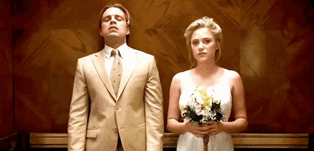 a man and a woman are standing next to each other in an elevator .