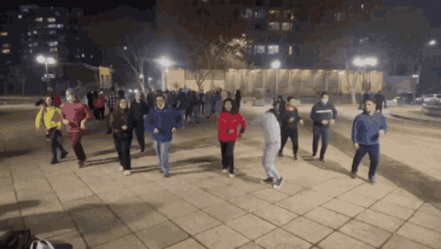 a group of people are dancing on a sidewalk