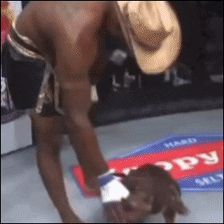a man wearing a cowboy hat is kneeling on a mat that says hard on it