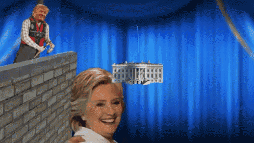a woman is smiling in front of a blue curtain with a white house hanging from it