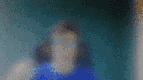 a blurry picture of a person wearing glasses and a blue shirt