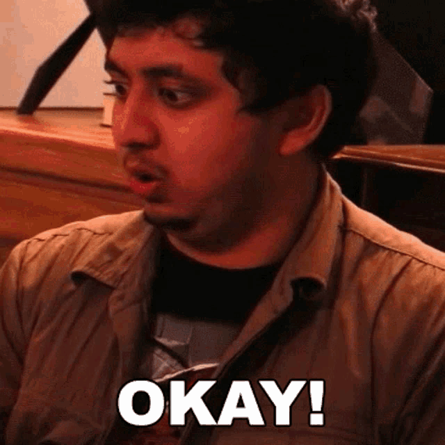 a man with a beard says okay in white letters