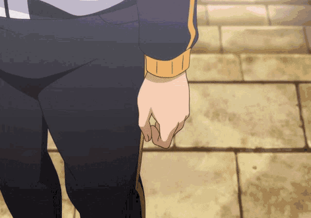 a close up of a person 's hand on a brick pavement