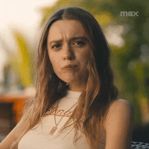 a woman is making a funny face in front of a max sign