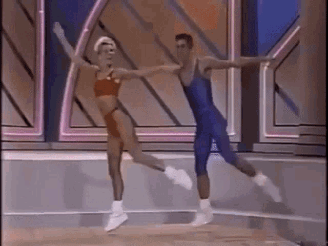 a man and a woman are dancing on a stage in a gym .