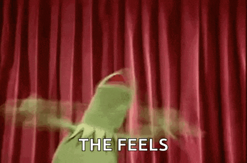 kermit the frog is dancing on a stage with a red curtain behind him .