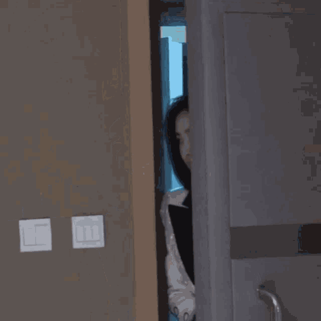 a woman in a tuxedo and white shirt is standing in a doorway .