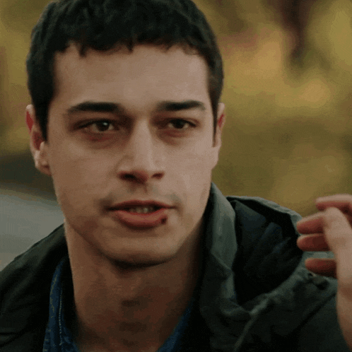a close up of a man 's face with a hand in his mouth