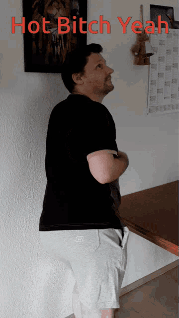 a man standing in front of a wall with the words hot bitch yeah written on it