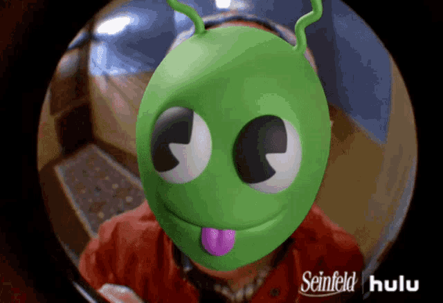 a green alien with a purple tongue sticking out is on a seinfeld hulu ad