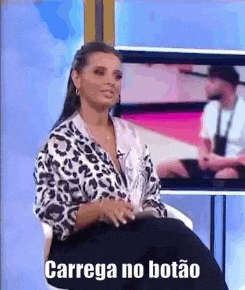 a woman is sitting in a chair with the words `` carrega no botão '' written on the screen .