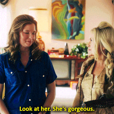 two women are standing next to each other with the words look at her she 's gorgeous above them