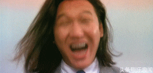 a man in a suit and tie is laughing with his mouth wide open