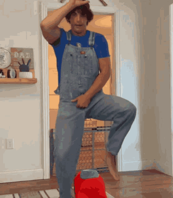 a man in overalls is standing in front of a sign that says " dad "