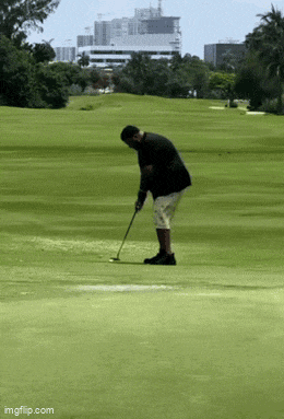 a man in a black jacket is playing golf