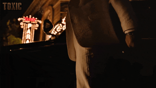 a man in a white suit stands in front of the paradise theater