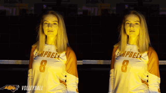 two women wearing campbell volleyball uniforms are standing in front of a volleyball net