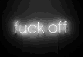 a neon sign that says `` fuck off '' is glowing in the dark on a black background .